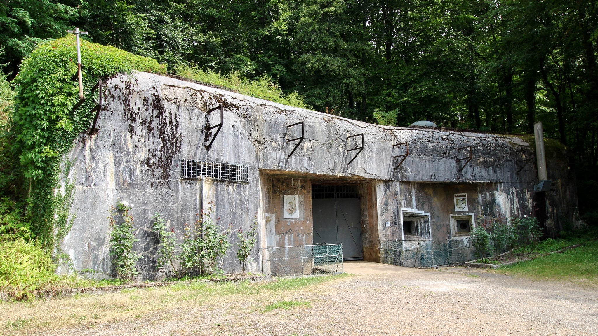Eingang einer in den Hang gebauten Festungsanlage mit Schiessscharten und Panzersperren